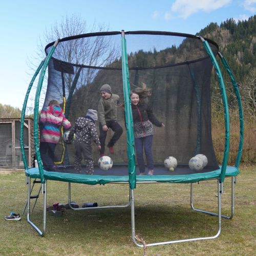 Kinder spielen mit Bällen auf dem Kettler Trampolin 305 in Navygrün.