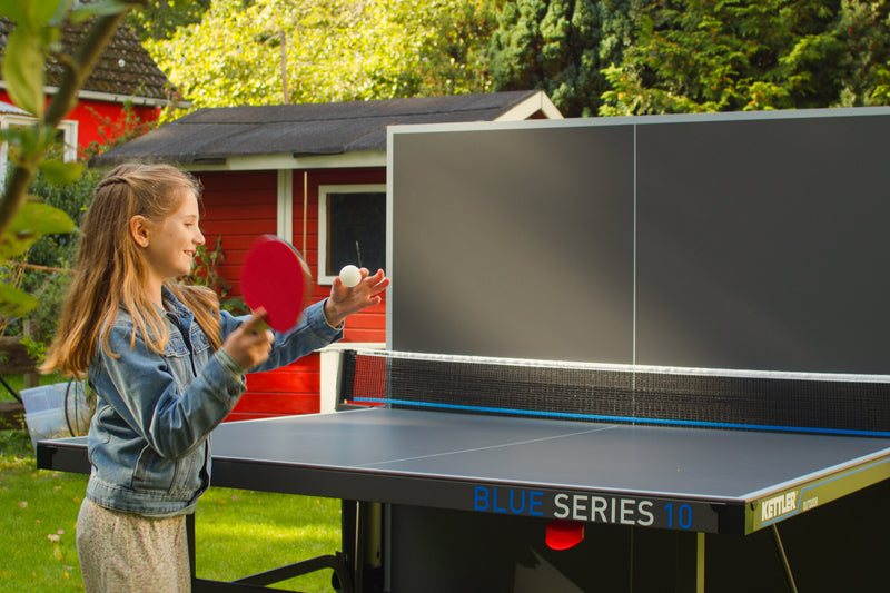 Mädchen spielt an der KETTLER Tischtennisplatte K10 Outdoor im Garten